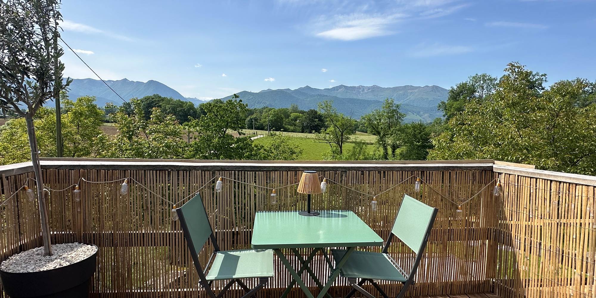 Coin repas sur la terrasse avec vue sur la nature et les Pyrénées