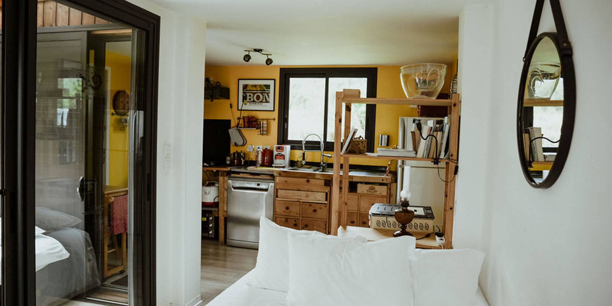 Le lit double, la bibliotheque et la cuisine