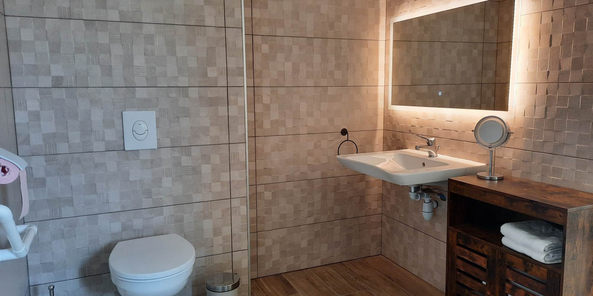 Une salle d'eau entièrement carrelée et des accessoires adaptés.