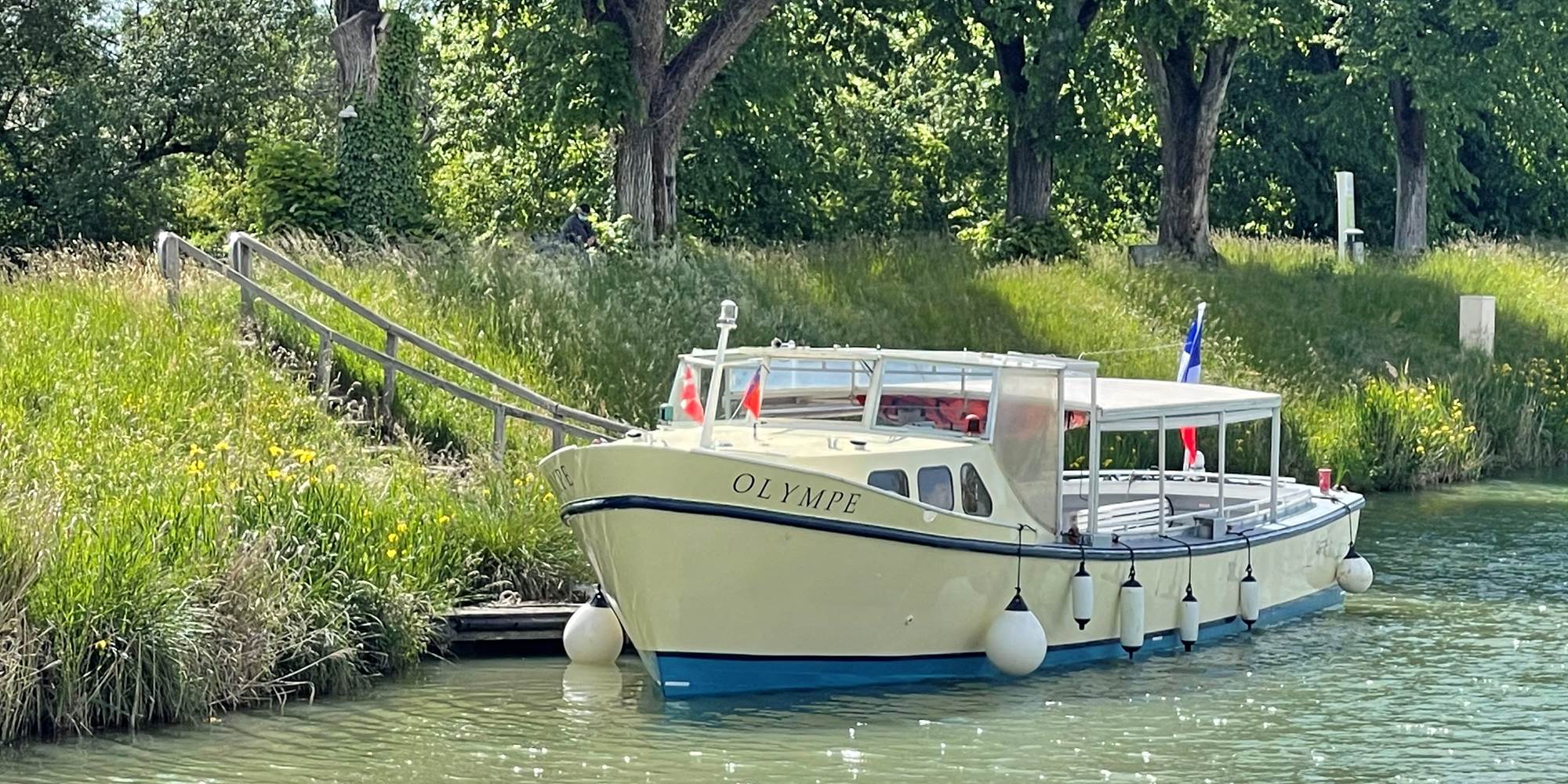 La vedette fluviale Olympe à son débarcadère, près de l'Ecluse du Tarn et des Cabanes du Port
