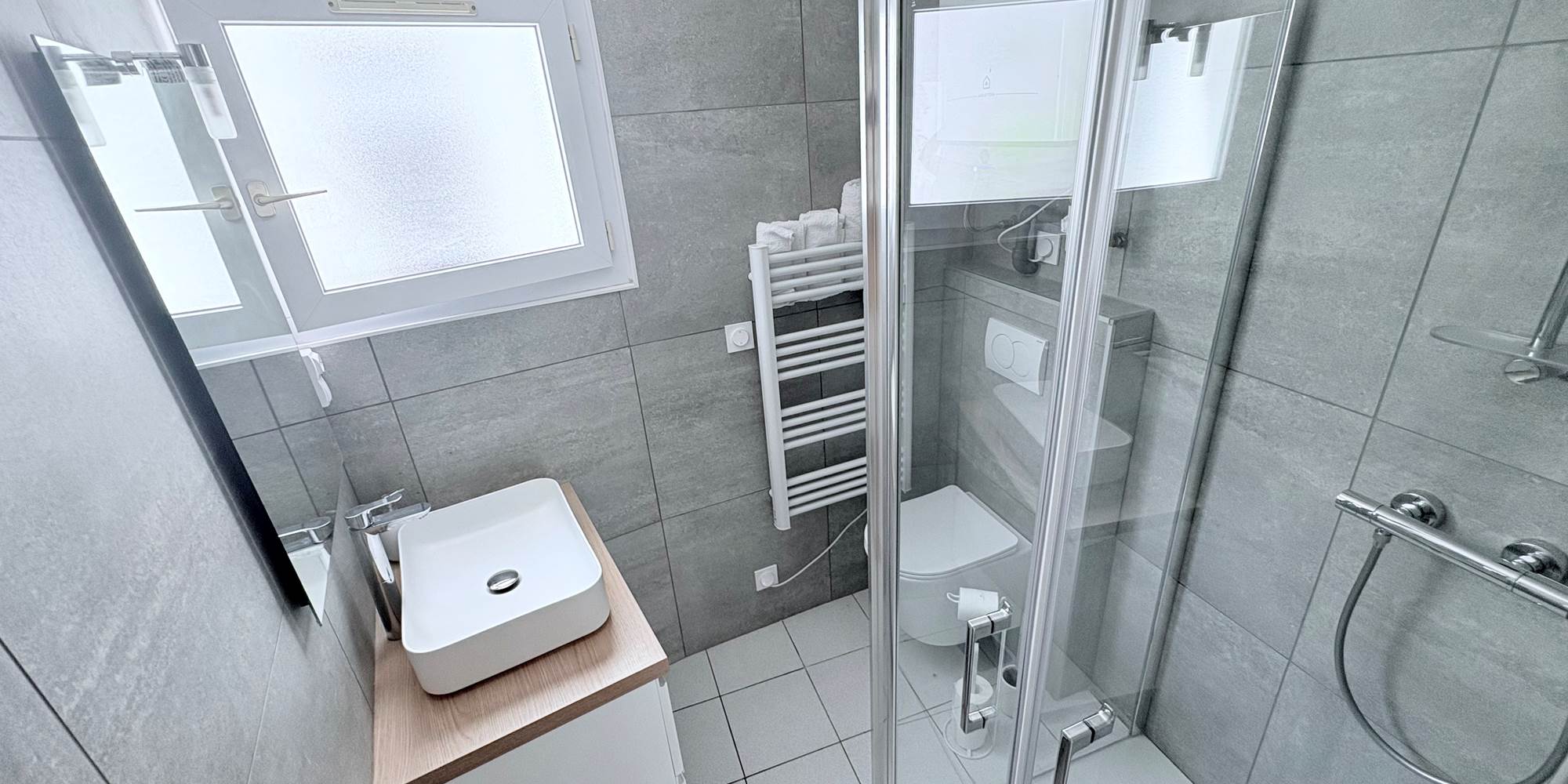 Maison Réthaise 2 – Salle d’eau lumineuse Espace soigné avec équipements modernes et rangements, pensé pour votre bien-être au cœur du centre-village.