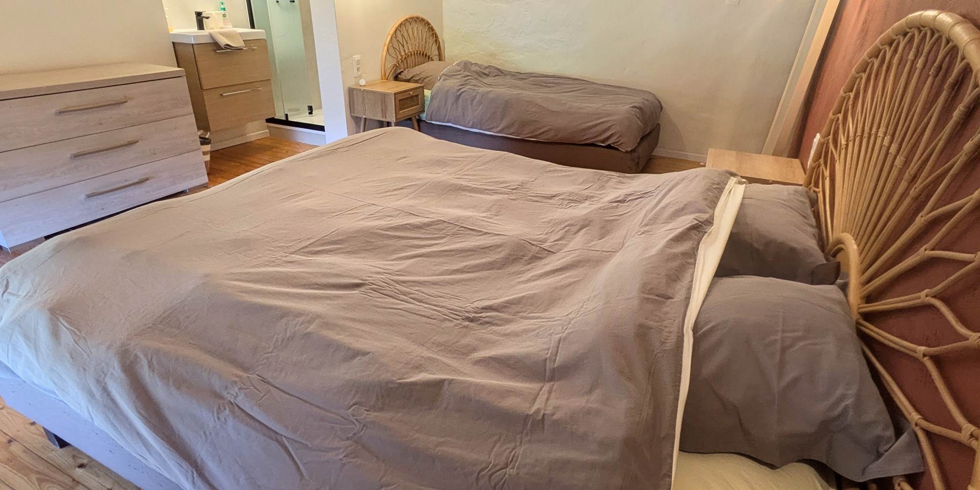 alt="Grande chambre avec couchages familiaux et douche privée dans le gîte pour groupes en Ardenne belge"