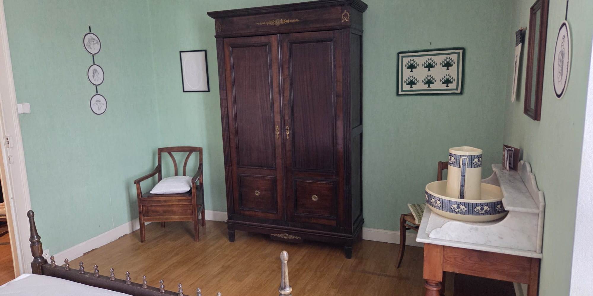 Chambre verte armoire et fauteuil