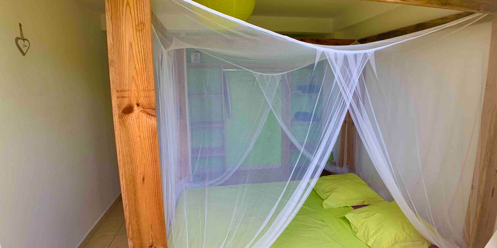 Chambre ventilée avec lit à baldaquin et moustiquaire