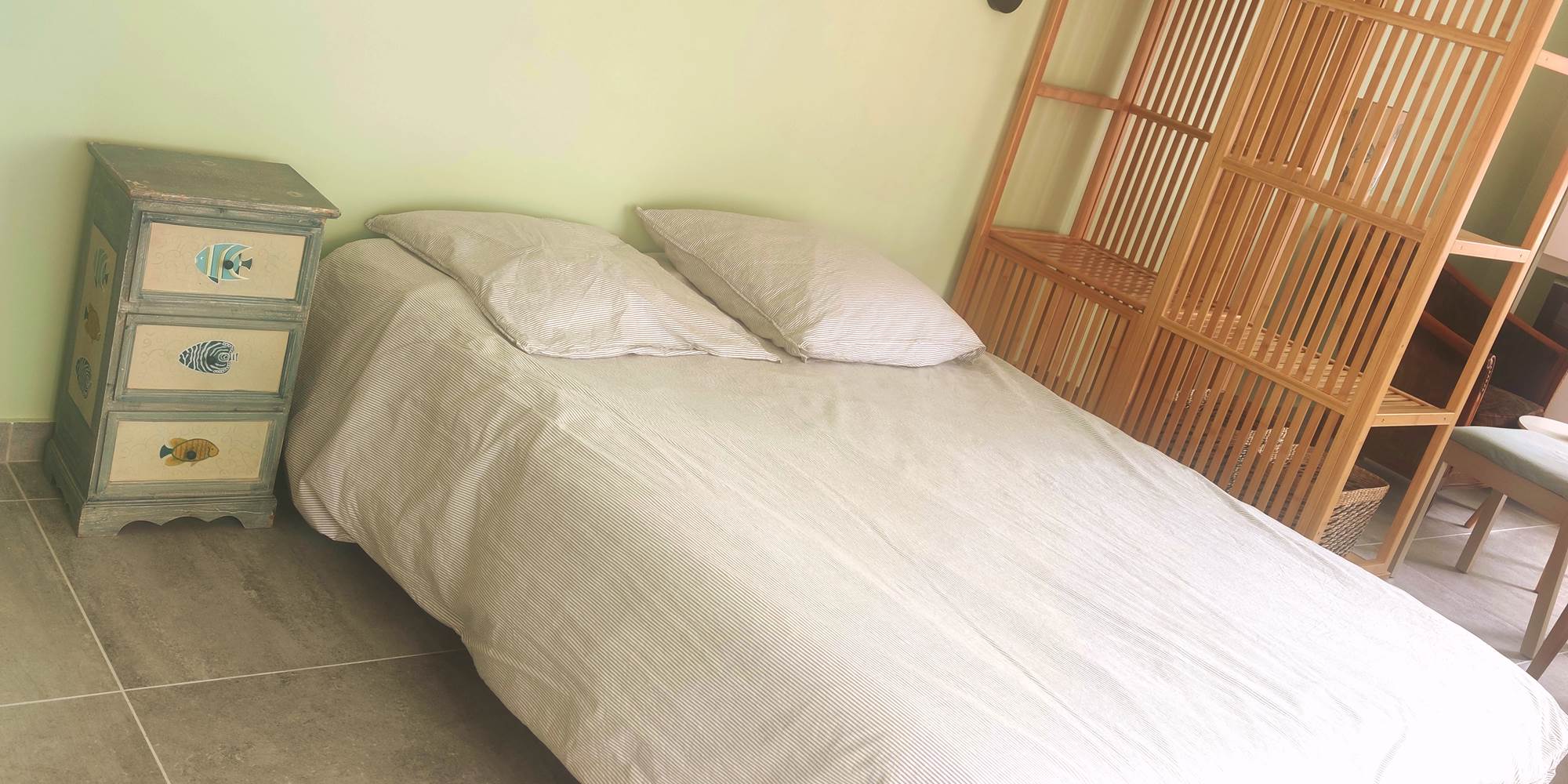 Chambre au style naturel et épuré Lit double, mobilier en bois clair et ambiance douce : parfait pour un séjour reposant au cœur de La Flotte.