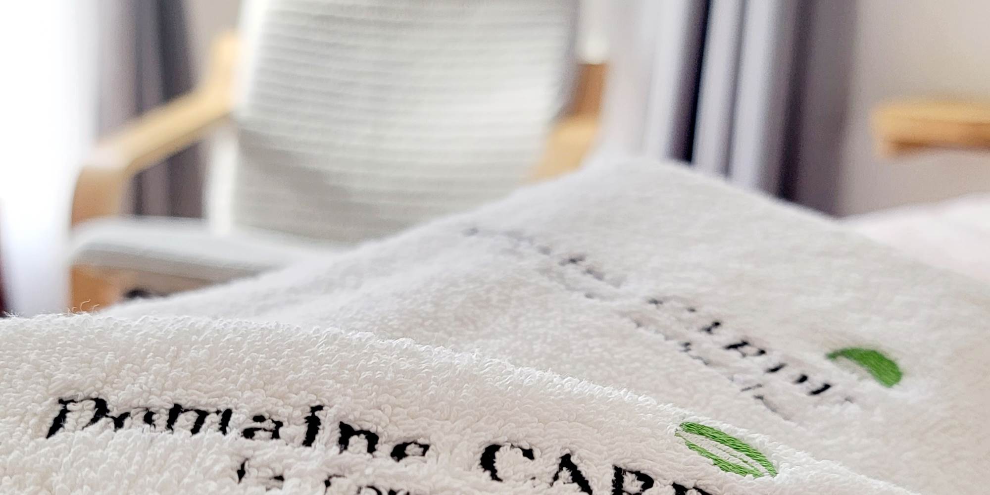 Linge de lit brodé au nom du Domaine Cardu pour un séjour confortable en Corse.