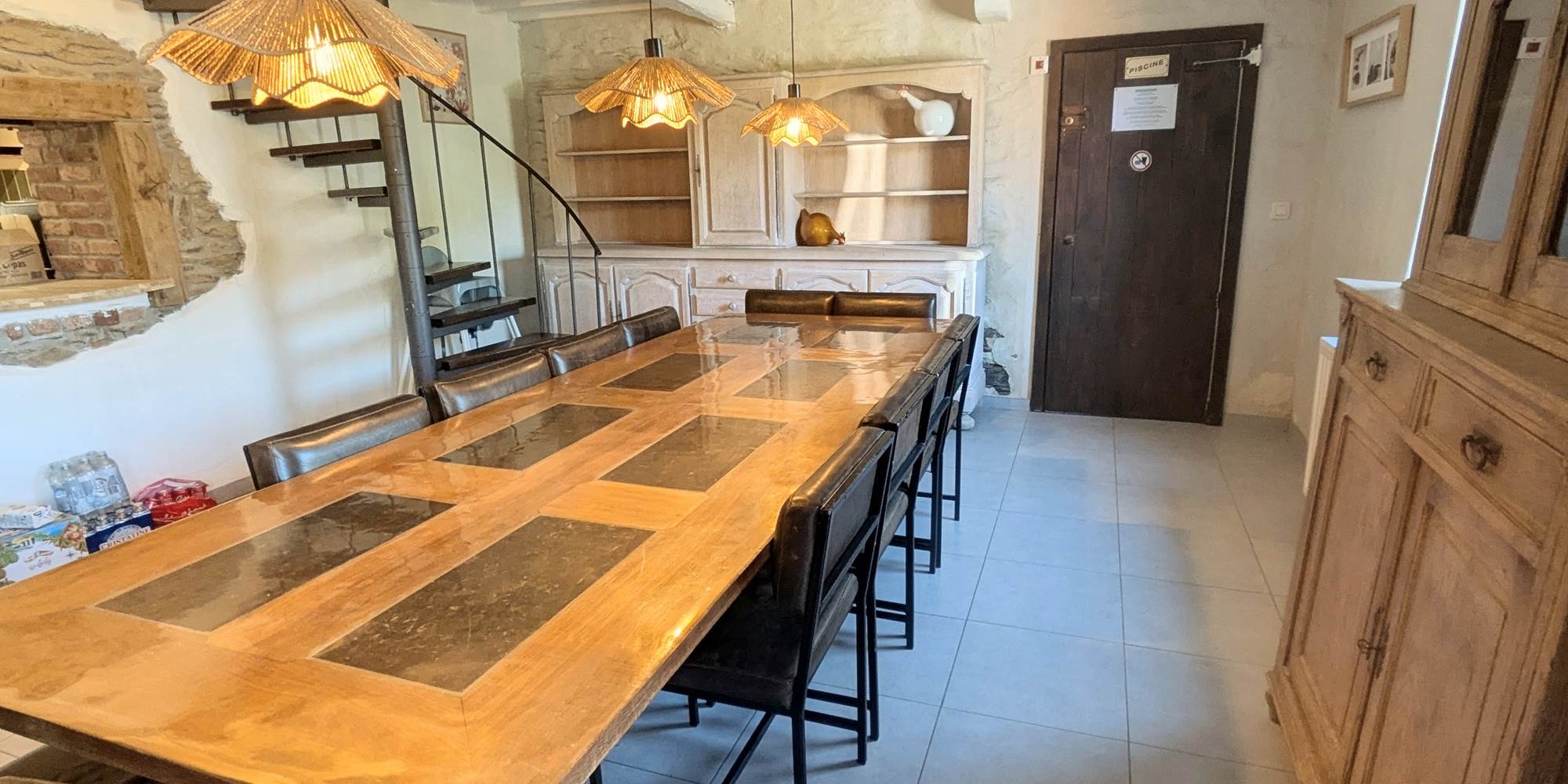 alt="Grande salle à manger du gîte familial avec table conviviale pour repas en groupe en Belgique"