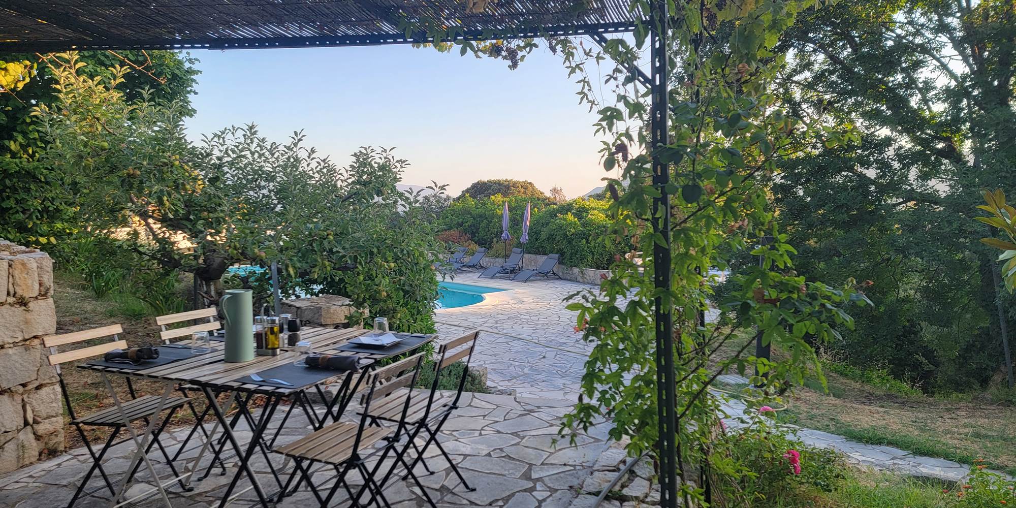 Table de déjeuner ou dîner en extérieur sous la pergola pour une soirée conviviale au Domaine Cardu.