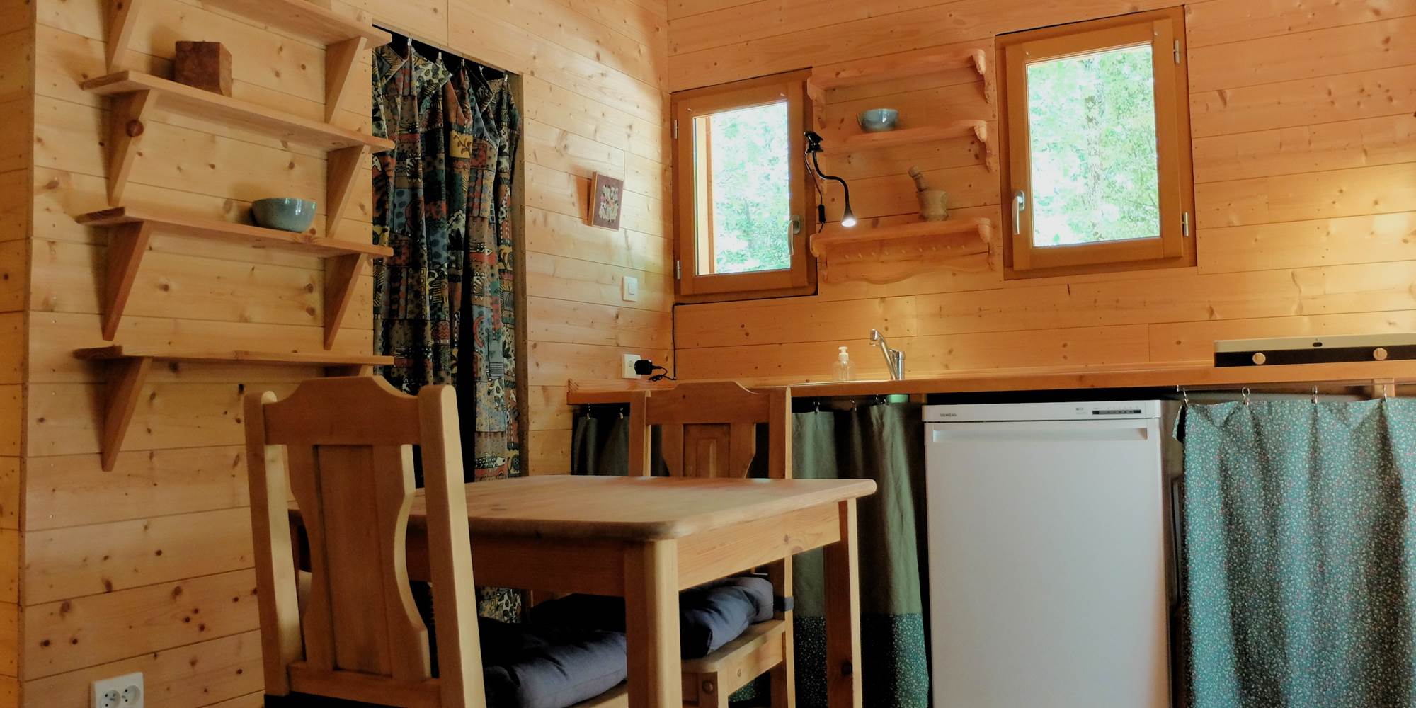 La cabane des 1000 Pailles coté Cuisine et l'accès au coin toilette derrière le rideau
