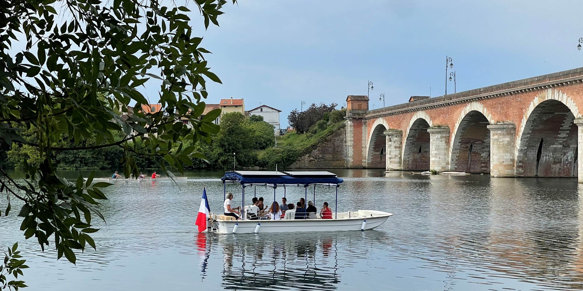 Le bateau 12 passagers Helios Confluences s'apprête à passer sous le Pont Napoléon de Moissac