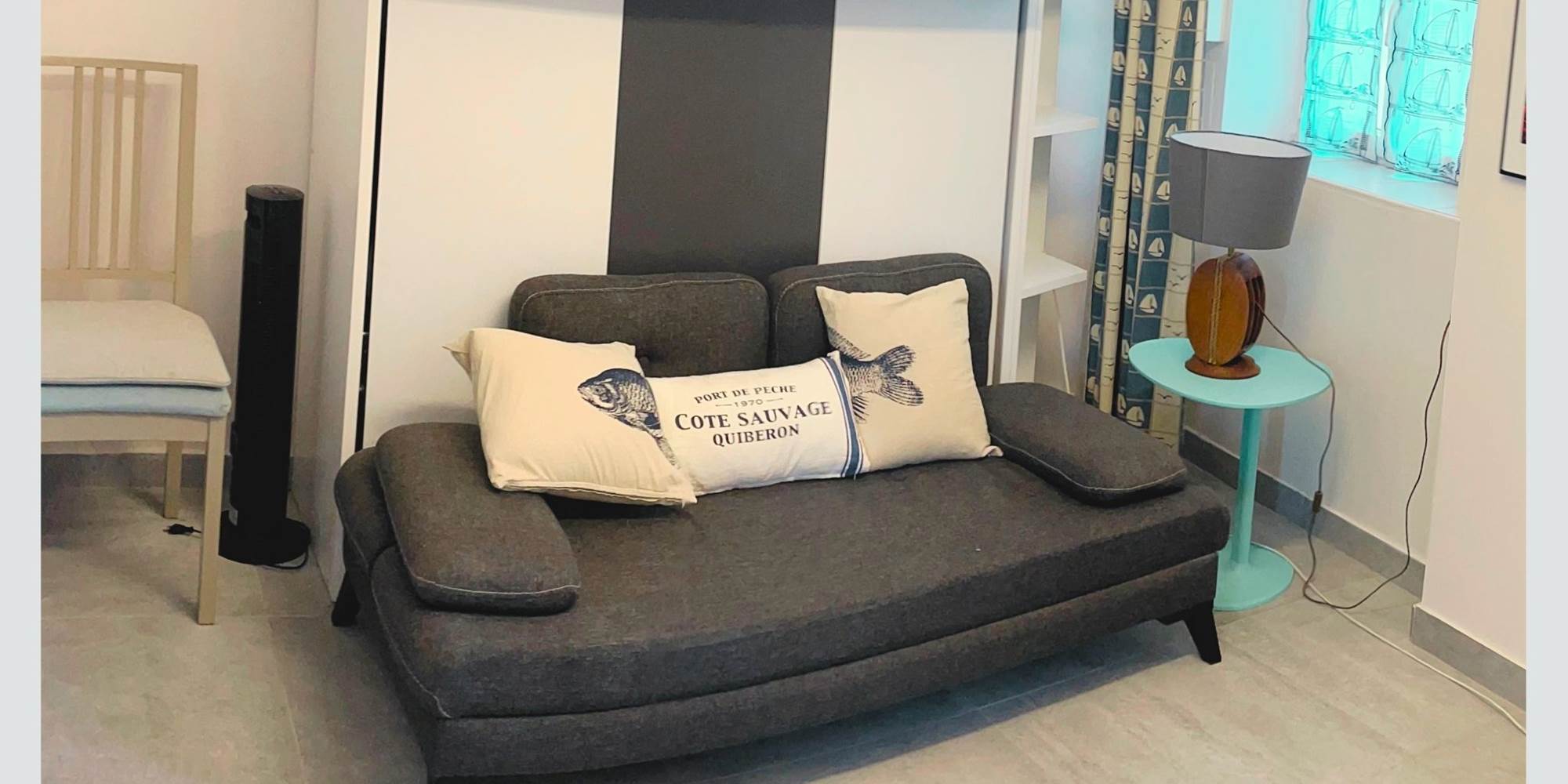 Studio – Coin salon avec charme rétais Ambiance chaleureuse et touche marine dans cet espace modulable en plein centre piéton. Confort assuré pour un séjour paisible à La Flotte