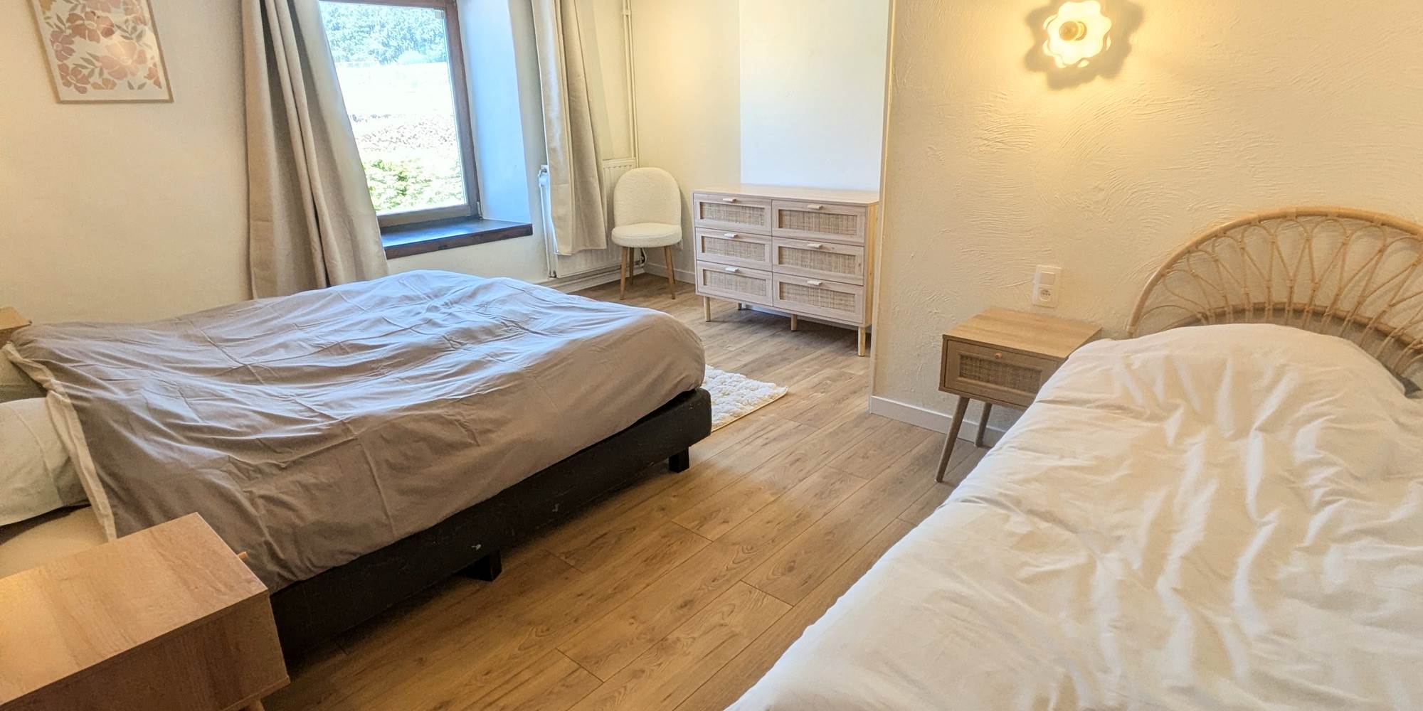 alt="Grande chambre familiale avec lit king size, lit simple et salle de douche privative dans le gîte en Belgique"