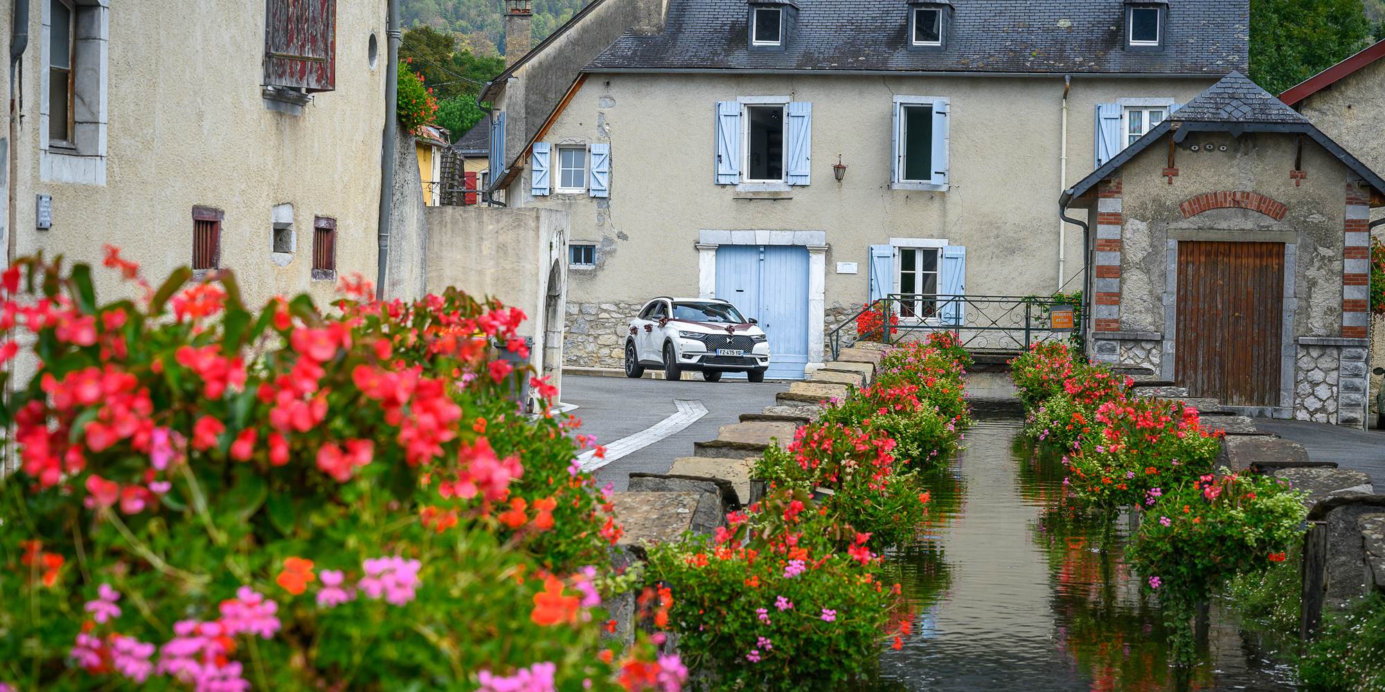 Gîte du Moulin : Le canal fleuri et la façade du moulin.