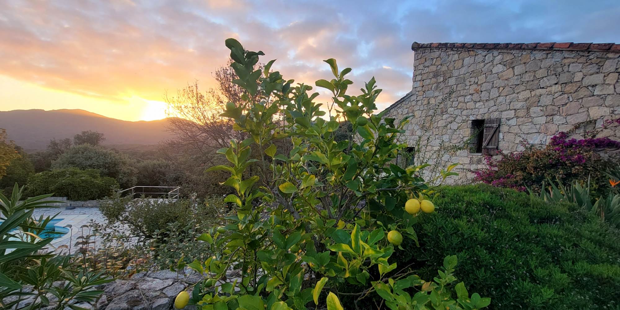 Maison d'hôtes traditionnelle en pierre de taille typique de la Corse du Sud au moment du crépuscule.