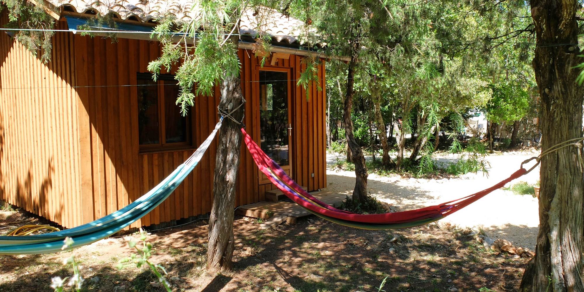 La cabane des 1000 Pailles avec ses deux hamac et le chemin d'accès aux hébergements