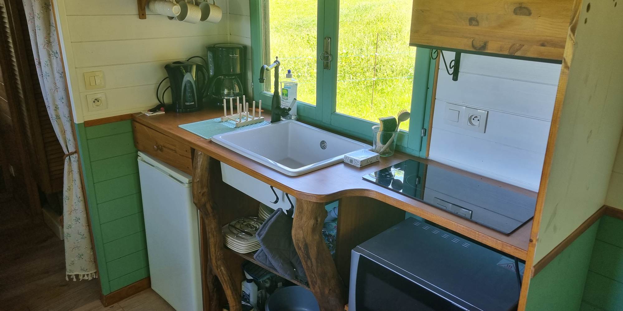 La kitchenette composée d'un réfrigérateur et son freezer, un four micro-onde et des plaques électriques.