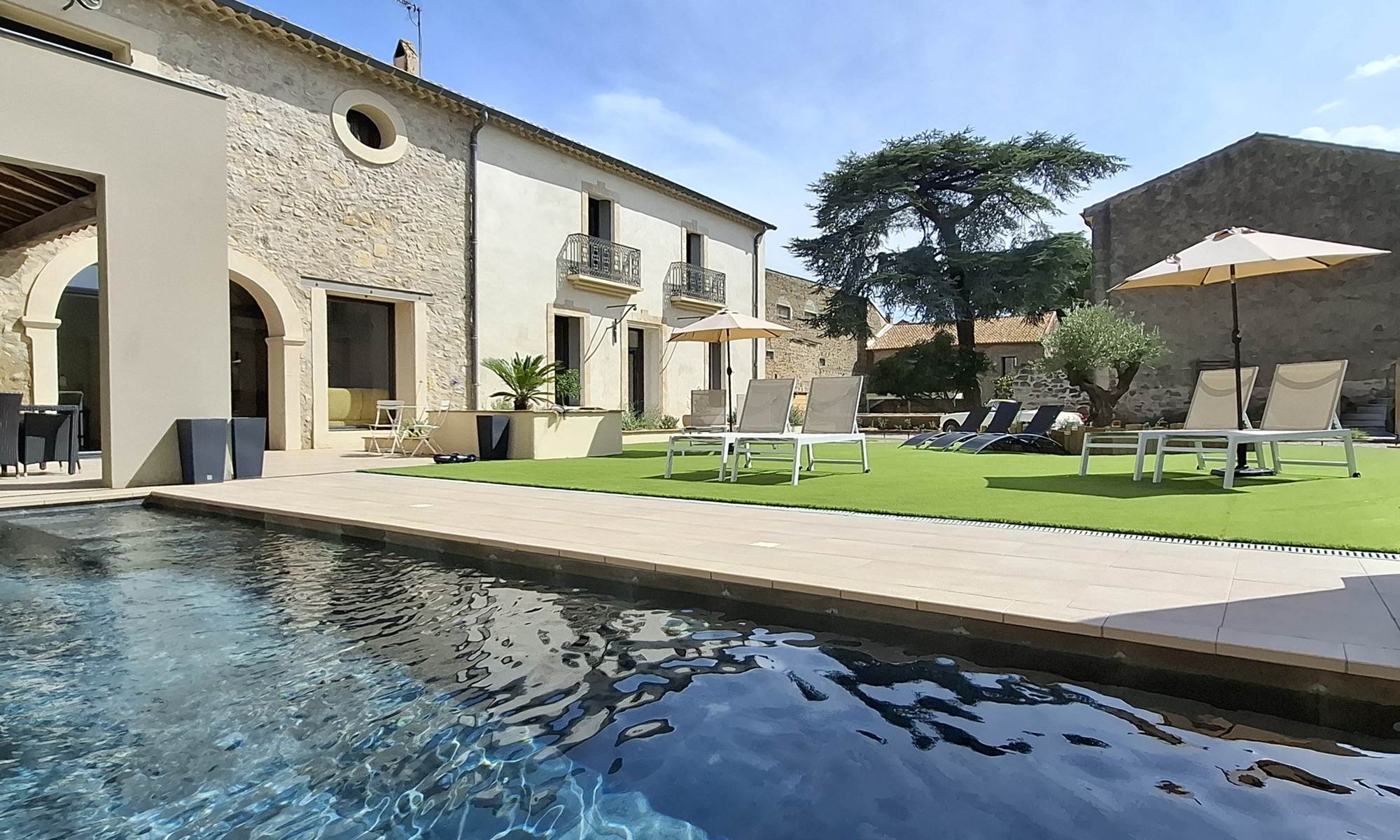 Vue d’ensemble des Gîtes de Monte Blanco avec la piscine et les façades rénovées, près de Pézenas.-galerie
