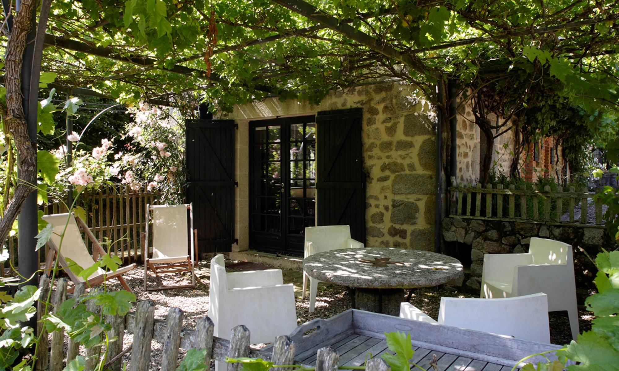 La terrasse privée de la Pichonna avec sa pergola recouverte de roses
