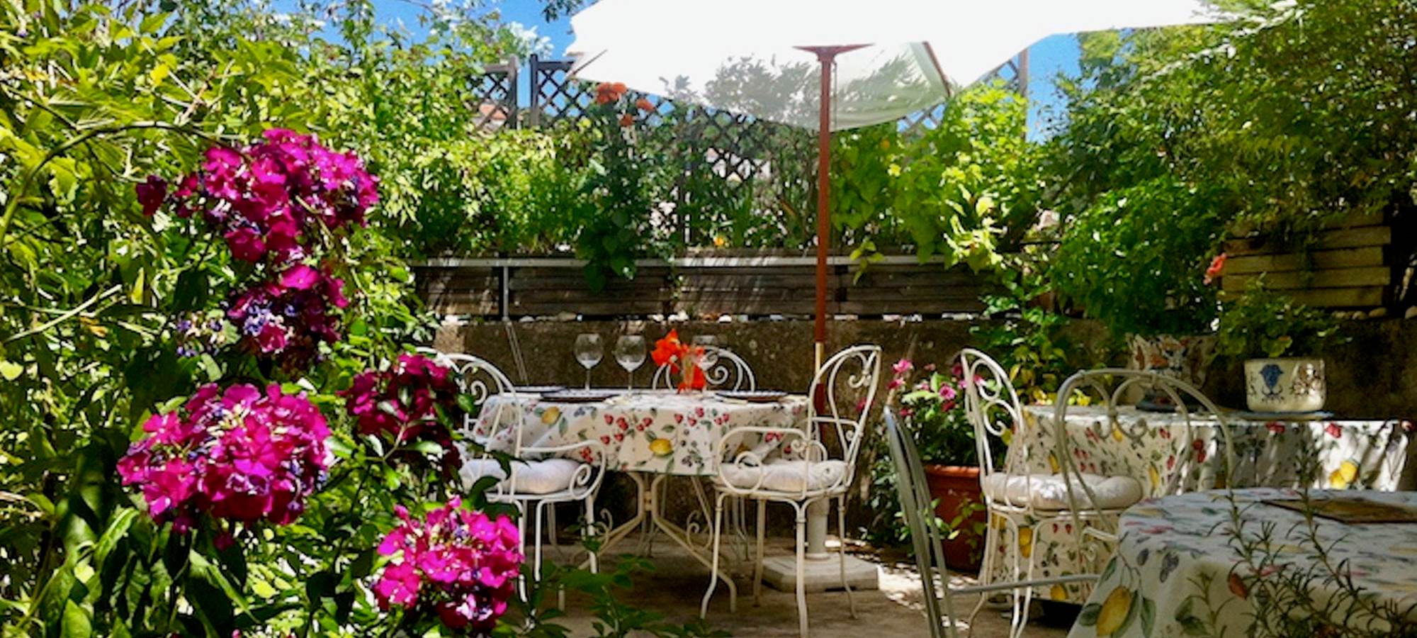 La terrasse fleurie pour dîners et petits-déjeuners
