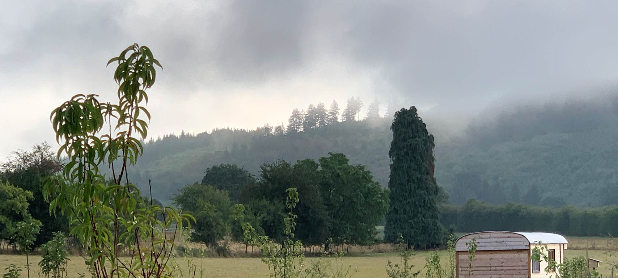 Les terres de la chouette, la roulotte et brume sur le Puy de la Roche