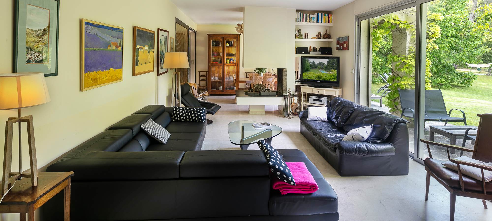 Salon avec cheminée ouverte donnant sur parc