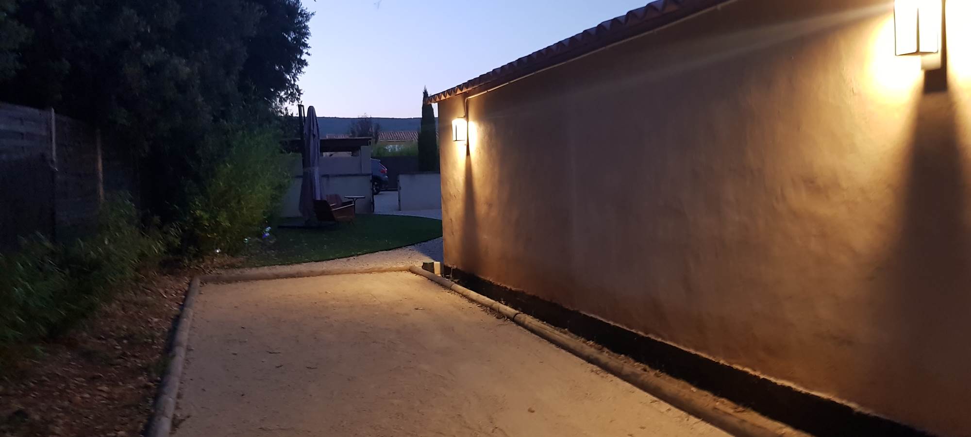 Terrain de pétanque éclairé la nuit avec prêt de boules adultes et enfants