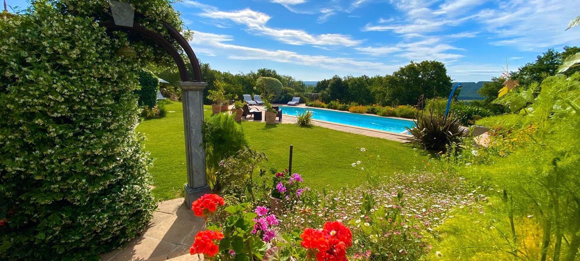 Vue sur piscine depuis le terrain de pétanque