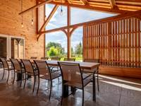 Terrasse couverte avec grande table en bois du pays