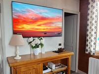 Télévision dans le salon avec à droite porte de la chambre