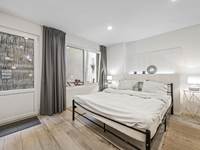 Slaapkamer met dubbelbed en privé terras