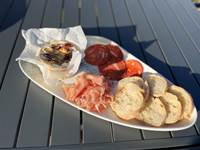 Camembert roti accompagné de charcuterie et de pain à partager à l'apéro