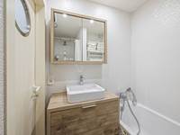 Badkamer met bad en douche en lavabo