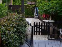 La grande terrasse avec la maison des enfants, la table de ping-pong et la zone déchets
