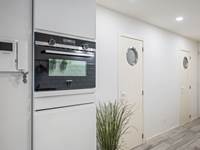 Keuken met oven en deuren naar badkamer en toilet