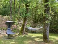 Espace détente avec hamac et fauteuil suspendu sous les arbres