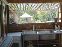 cuisine d été camping, evier, gaziniere et vaisselle à disposition, frigidaire à reserver