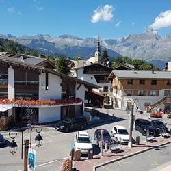 Vue du salon sur le syndicat du tourisme et  le parking .Chaines des ARAVIS derrière