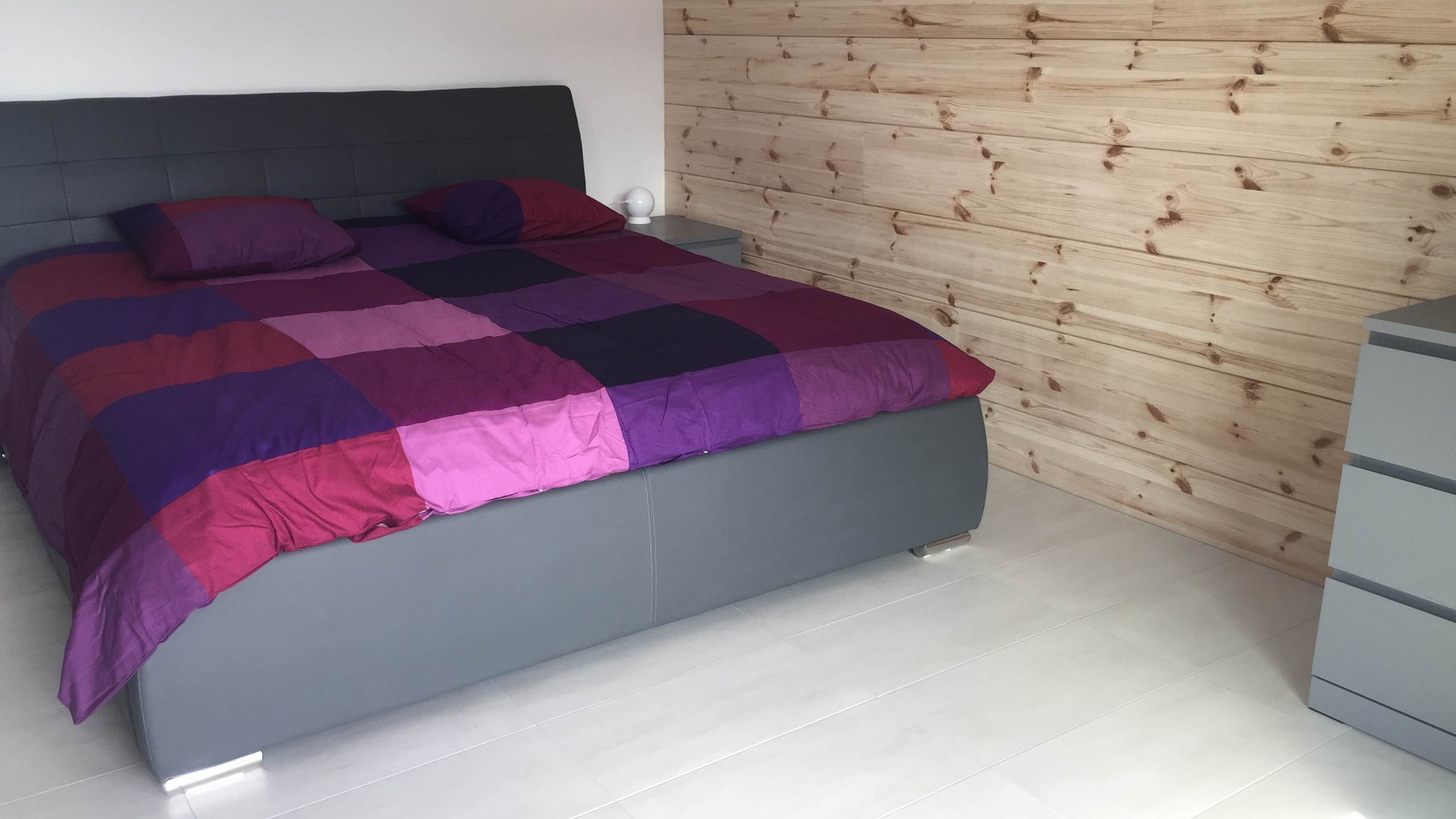 Chambre avec lit King size et mur en bois finlandais