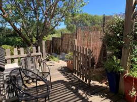 La petite terrasse s'ouvre sur le vieil amandier