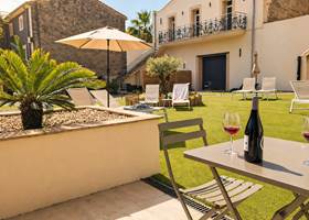 Terrasse ensoleillée aux Gîtes de Monte Blanco avec table dressée et espace détente au printemps dans l’Hérault