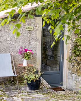 Façade en pierre de la Cabane avec coin détente extérieur