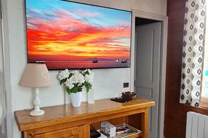 Télévision dans le salon avec à droite porte de la chambre