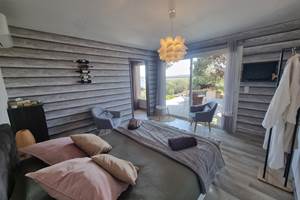grande chambre avec coin salon séparée de la cuisine et de la salle d'eau