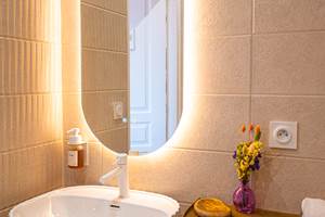 Des courbes et des lumières chaleureuses pour prendre soin de soi dans la salle de bain.