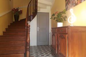 Entrée de la maison d'hôtes, avec carrelage et escalier d'époque