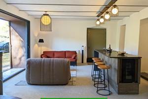 Grande pièce à vivre : véranda / coin bar avec tabourets / cuisine équipée / cave à vin approvisionnée