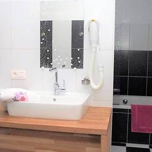 Jolie salle de bain de la chambre familiale. Baignoire / Douche - WC - deux Lavabos