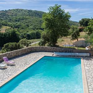 La piscine dans un cadre calme, avec transats et grande terrasse