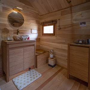 Salle de bain avec douche, lavabo et toilette sèche dans le zôme