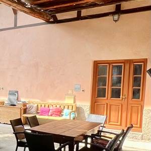 Entrée du gîte la glycine avec son salon de jardin sous la terrasse couverte